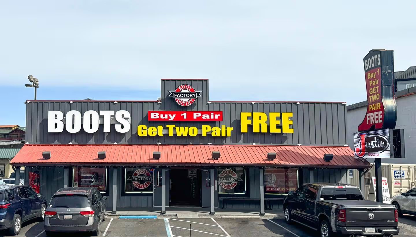 Boot Factory Outlet storefront on the Parkway in Pigeon Forge with its red metal awning and "Buy 1 Pair Get Two Pair Free" sign