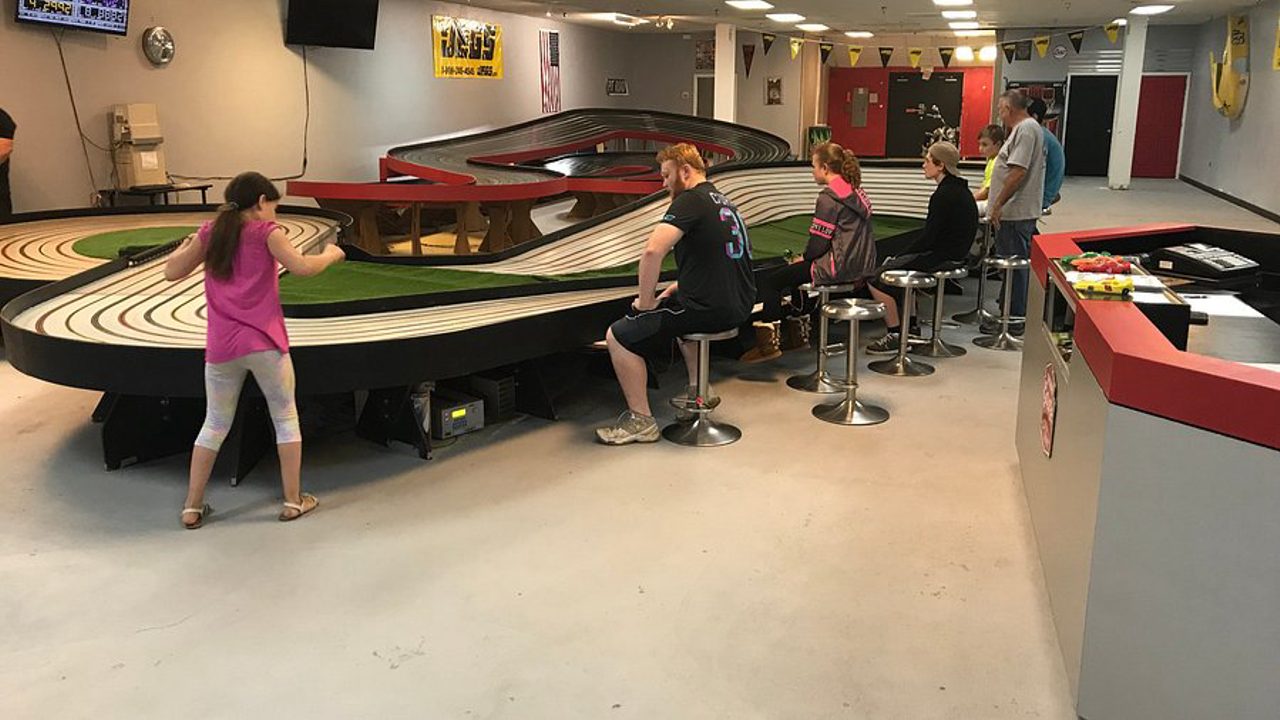 Racers at the long multi-lane slot car track inside The Checkered Flag