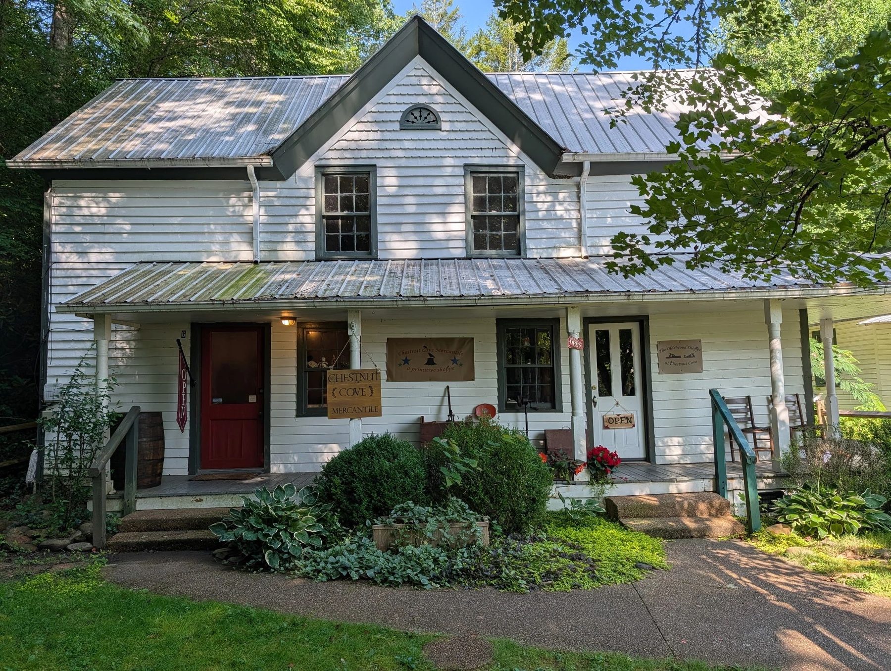 White farmhouse storefront of Chestnut Cove Mercantile with a covered front porch