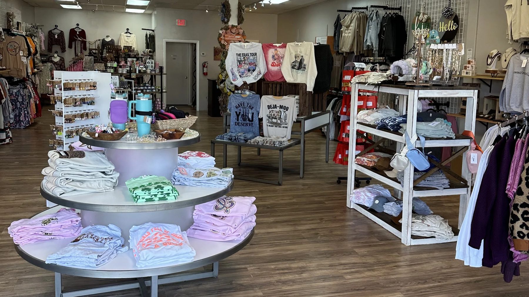 Bright sales floor of Coal Miner's Daughter Mercantile with apparel tables and racks