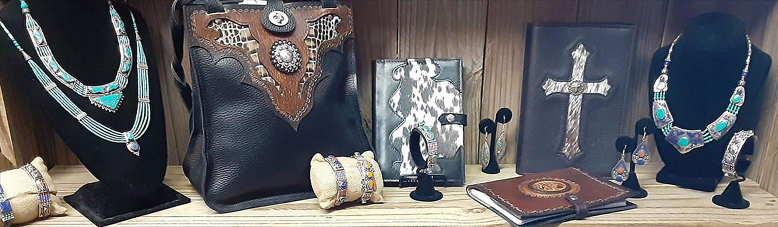 Handmade leather goods and turquoise jewelry displayed on a wooden shelf at Country Cobbler