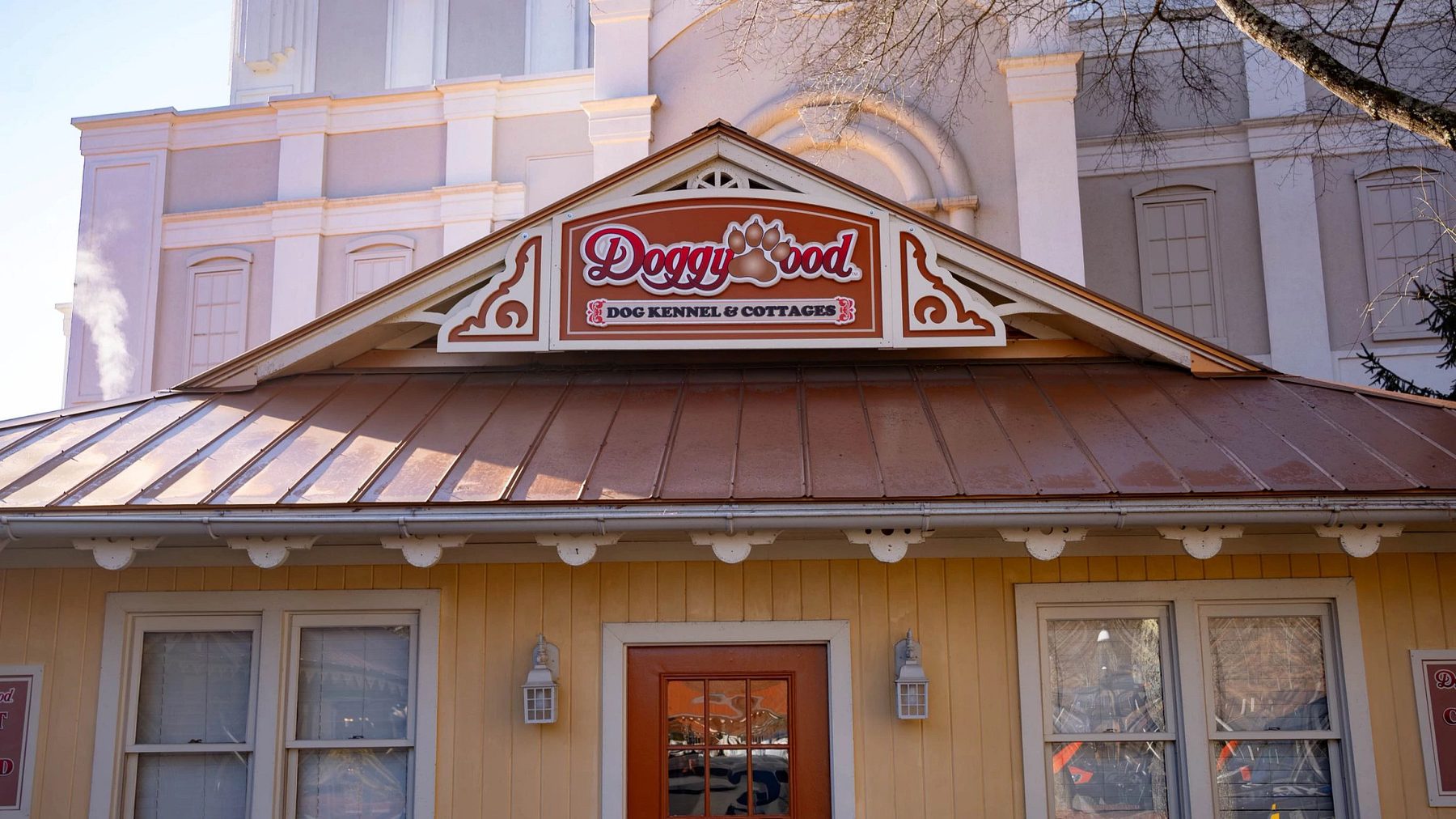 Front of the Doggywood dog kennel and cottages building at Dollywood with its paw-print sign over the entrance