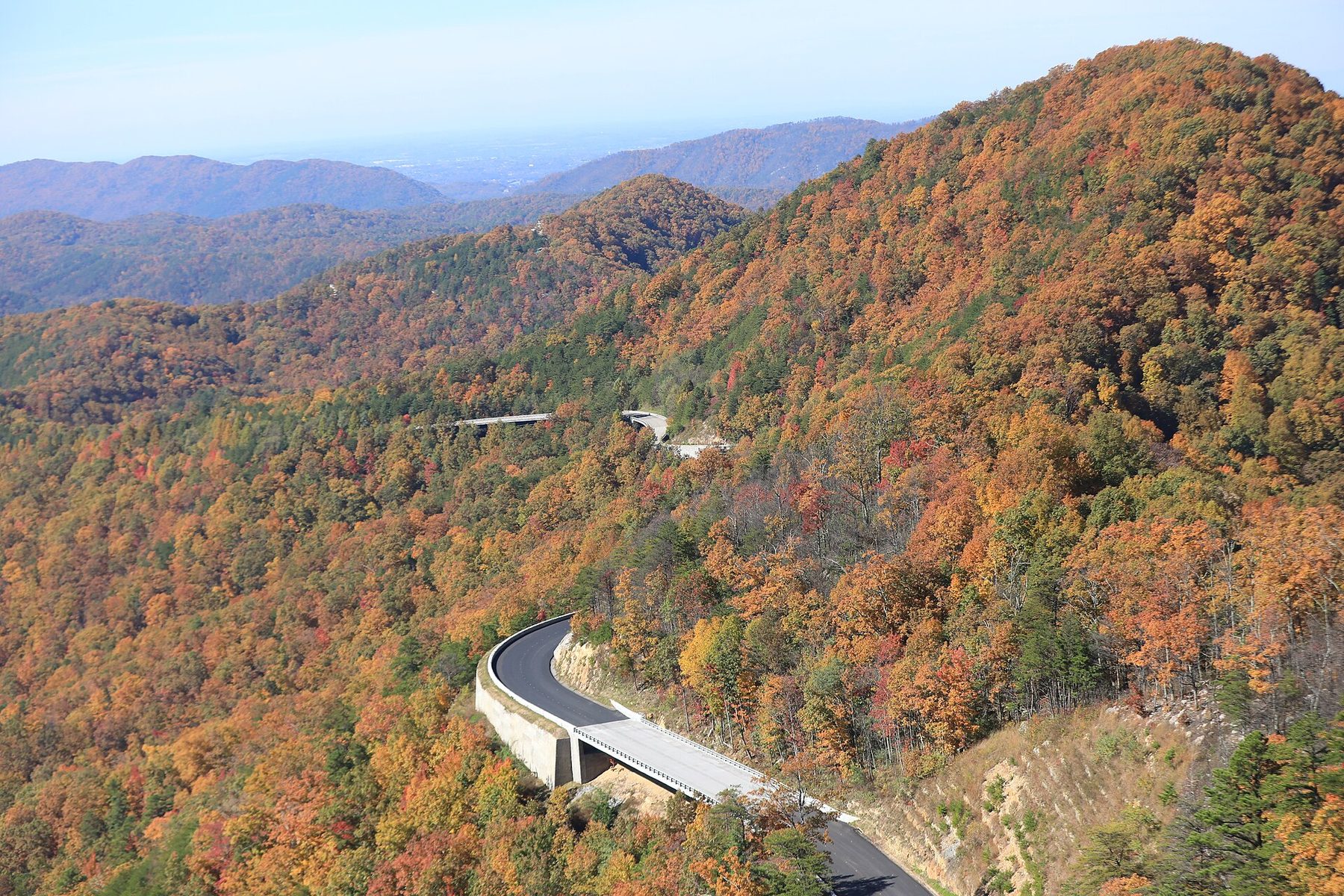 Foothills Parkway curving along a fall-colored ridge between Wears Valley and Walland, with the Great Smoky Mountains foothills beyond