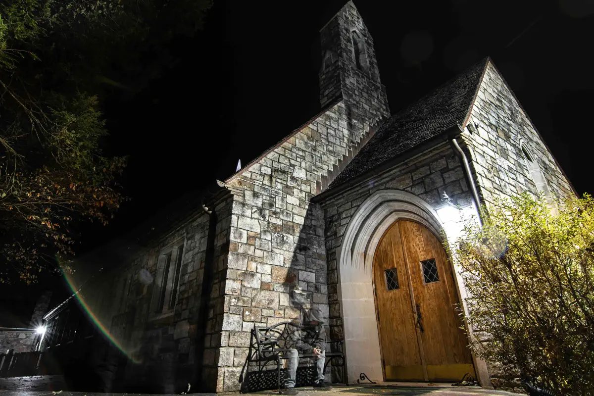 Stone chapel with an arched wooden door lit up at night, a stop on the Gatlinburg ghost tour