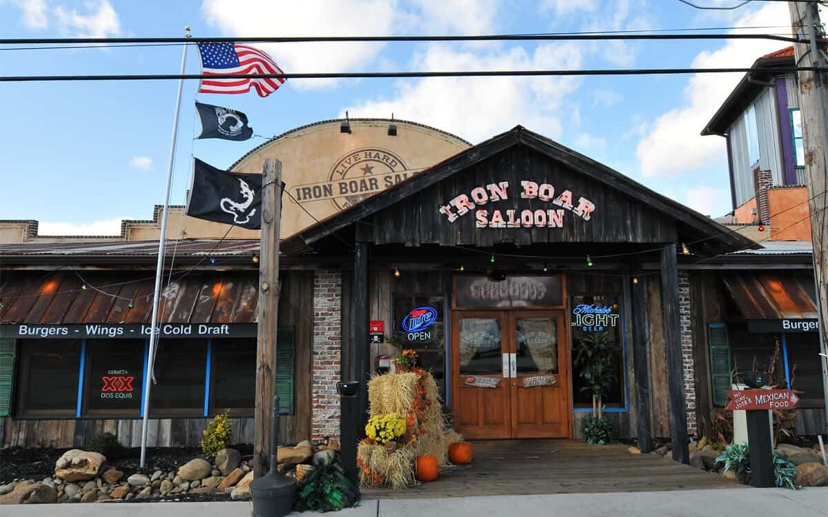 Rustic wood front of the Iron Boar Saloon on Waldens Main Street with flags and fall decorations