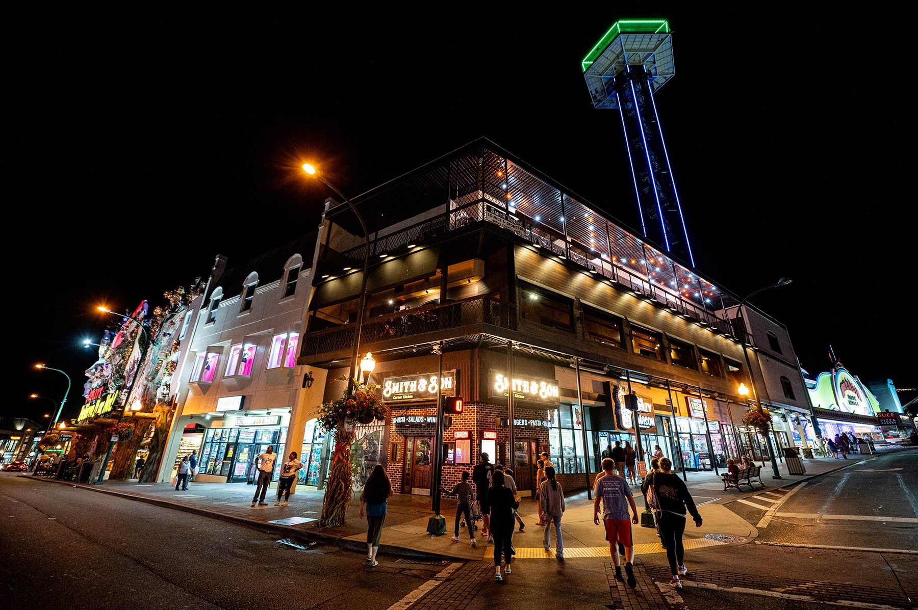 Smith & Son Corner Kitchen building on the Gatlinburg Parkway at night, with the Space Needle lit up behind it