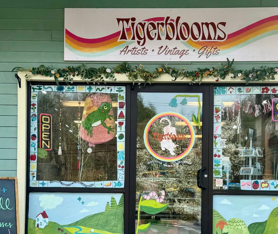 Tigerblooms storefront with its rainbow sign, painted windows and flower garland over the door
